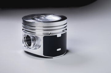 The new piston of the internal combustion engine with dust on the sides on a gray gradient background. The concept of new engine parts