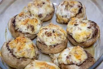 Stuffed mushrooms stuffed with cheese, mushroom stalks and onions. In a baking dish.