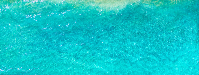 Summer vacation background. Drone aerial view of turquoise ocean. Banner format