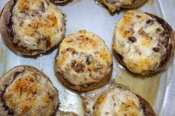 Stuffed mushrooms stuffed with cheese, mushroom stalks and onions. In a baking dish.