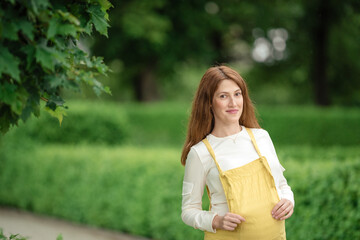 Obraz premium Beautiful pregnant girl walking in the Park.