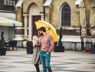 Young couple holding an umbrella together