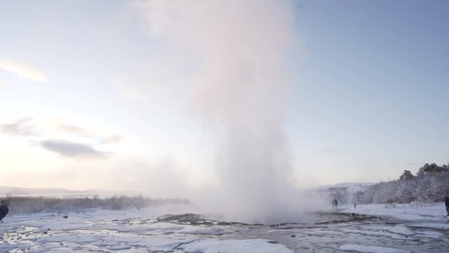 Geysir in Island bricht aus in Zeitlupe mit Schnee und Sonnenaufgang