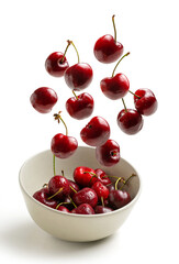 cherries flying in white bowl isolated from background