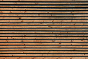 Horizontal photo wall with wooden slats or brown panels.