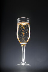Glass full of champagne on black background