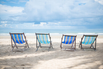 Beach chair on the beach,  blue sky and clouds. Summer vacation and travel concept.