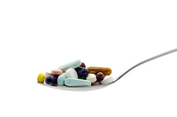 Medicine pills on spoon on white background