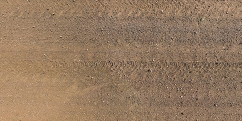 view from above on texture of gravel road with car tire tracks