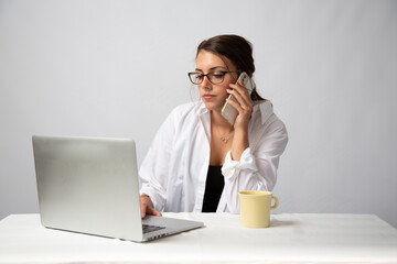 Young Model with glasses on computer in the office on a white background.