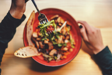 Top view of woman sitting in restaurant and having salad for lunch. Healthy lifestyle concept.
