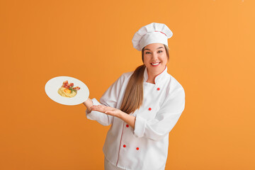 Young female chef with tasty dish on color background