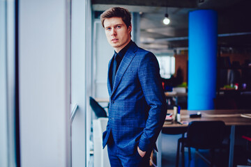 Caucasian male colleague in formal suit standing in office interior