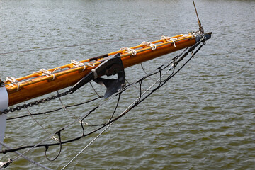 Bowsprit of a sailing ship with boat anchor attached, before calm sea water, copy space, horizontal...