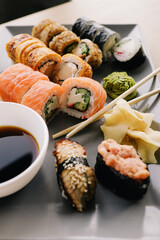 Freshly cooked sushi chef, delicious big rolls with avocado, cheese, salmon, sesame seeds 