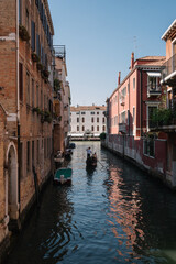Fototapeta na wymiar Gondolier drives a gondola on a canal in Venice, Italy.