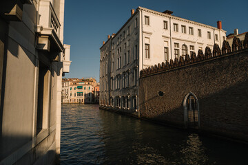 Deserted canal of Venice, Italy, buildings flooded with pre-sunset warm light.