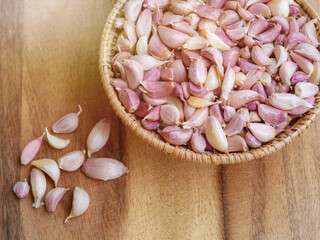 Garlic cloves in basket on wooden board, Herbs with pungent smell, Spicy taste and medicinal properties, Health care concept.