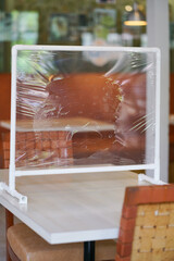 New normal. Restaurant reopening with partition shield setting on the dining table to keep social...