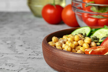 Clay plate of chickpeas and cut cucumbers and tomatoes. Healthy eating