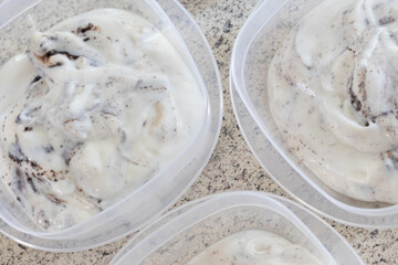  Homemade cookies and cream yogurt put into individual containers on a domestic kitchen counter.