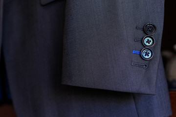 Close up of a man's suit sleve with buttons