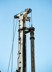 Fototapeta na wymiar Old Oil drill against the light blue sky