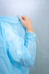 Doctor wearing blue single use gown for covid19 medical procedure for coronavirus protection