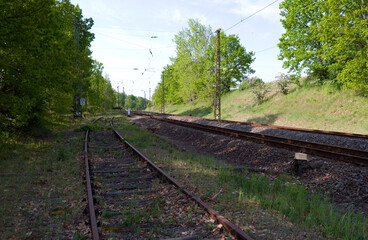 Transportation / Railway: Old and no longer used siding at the edge of an electrified double-track railway line in Central Germany on a sunny day in May