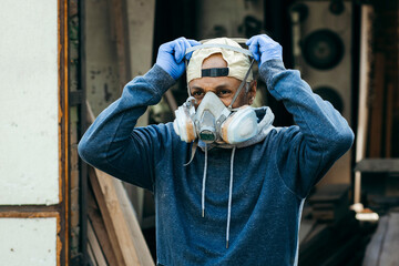Close up portrait of male worker wearing full face respirator mask for working in hazard...