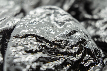 Black pieces of oil close up. Macro photography