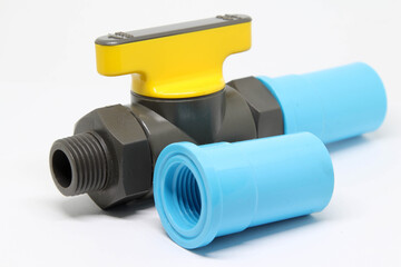 PVC ball valve and PVC pipe fitting on white background.