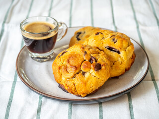 Chewy chocolate chip soft cookies with cup of hot black coffee, selective focus on cookies