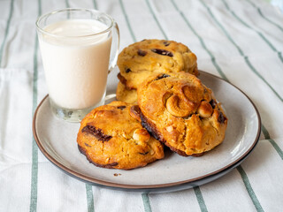 Chunky chewy chocolate chip soft cookies with cup of cold milk for breakfast, selective focus on cookie