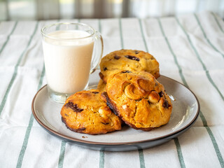 Chunky chewy chocolate chip soft cookies with cup of cold milk for breakfast, selective focus on cookie