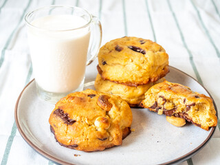 Chunky chewy chocolate chip soft cookies with cup of cold milk for breakfast, selective focus on cookie
