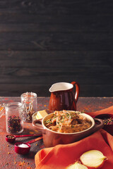 Tasty beef stroganoff in pot on table