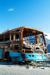 The frame of the burnt bus on the mountain road in Pakistan. Few buses in the valley. Dangerous...
