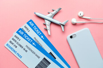 International flight concept with tickets, airplane and smartphone on a pink background.