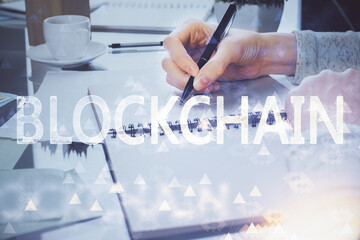 Cryptocurrency hologram over woman's hands writing background. Concept of blockchain. Multi exposure