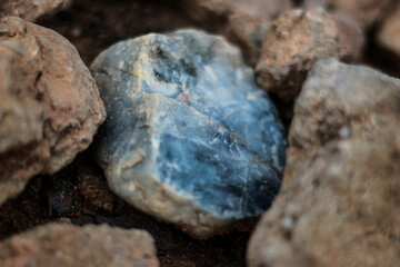 Fototapeta premium close up of a blue rock surrounded by regular rocks