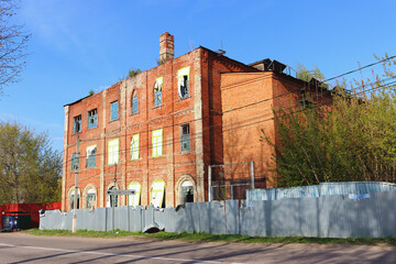 Side view of an historic abandoned brick building with broken windows of the Zaraysky feather factory founded in 1858 by German businessman August Reders. Translation: "Soviet Street"