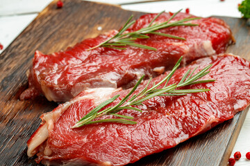 Barbecue veal steaks with rosemary on wooden board