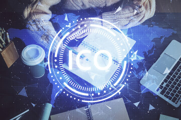 Cryptocurrency hologram over hands taking notes background. Concept of blockchain. Multi exposure