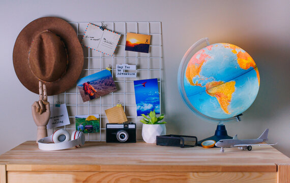 Modern home office workplace with inspirational printed photos on the mood board near glowing Earth globe