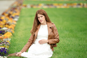 Charming pregnant woman relaxing in the park