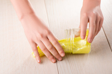 Kid getting a yellow slime out of a jar