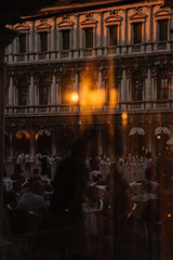 View through the window to the restaurant of Venice and the people reflected in the window from the street, Italy.