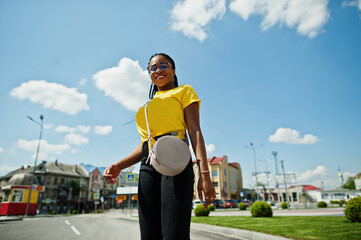 Portrait of  black African American woman in yellow t-shirt and glasses.
