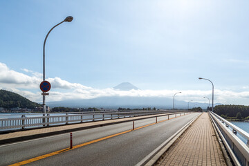 Bridge road over Kawaguchiko lake with Mountain Fuji at the background - 354953185